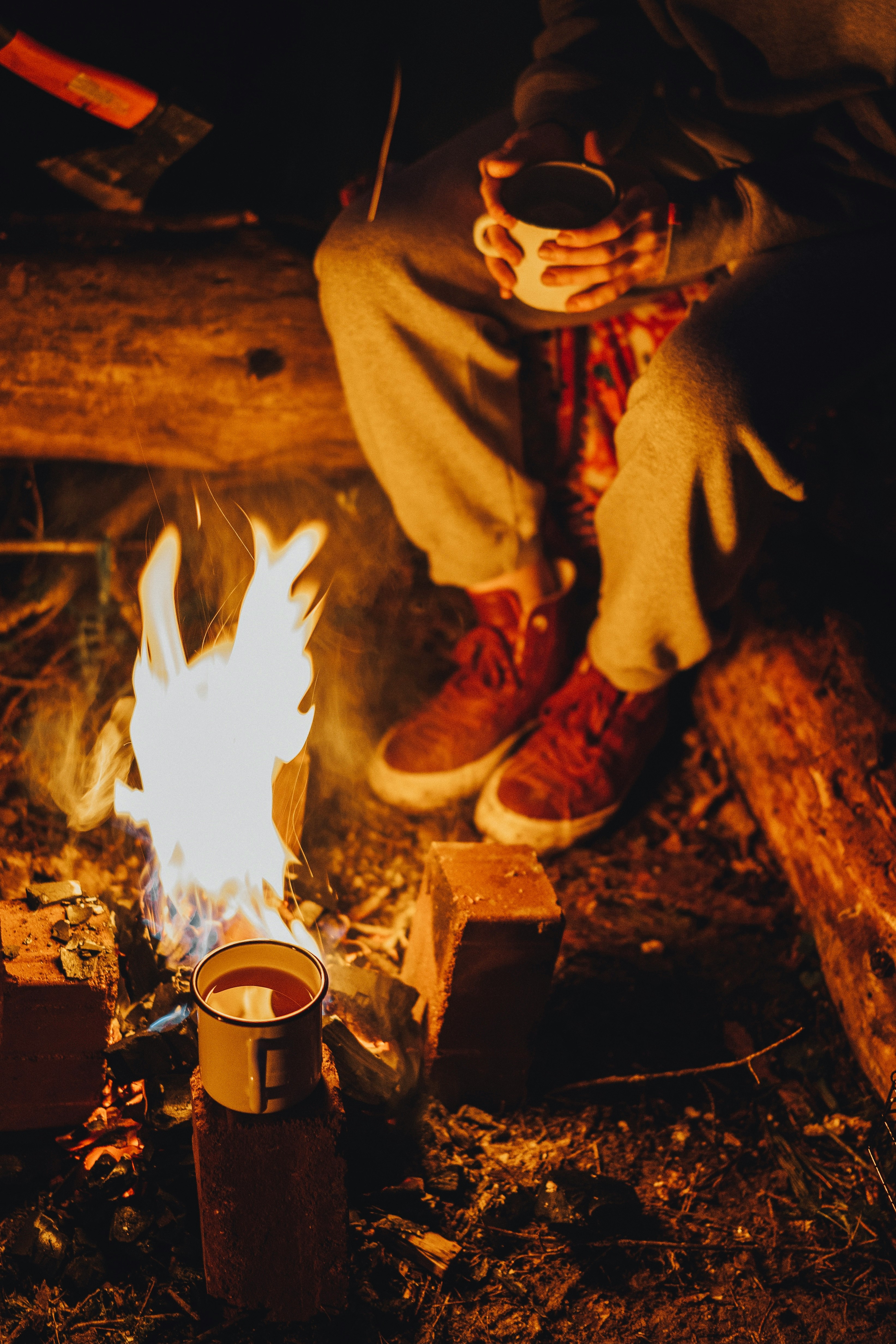 person in brown leather boots holding white ceramic mug